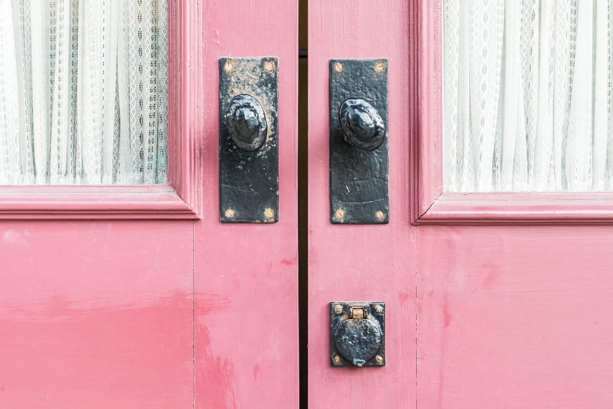 Door furniture on a pink door
